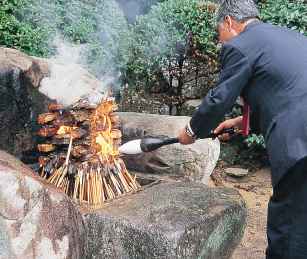 使われた筆を燃える炎に入れる様子の写真