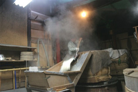 蒸した米をすくって出しているところの写真