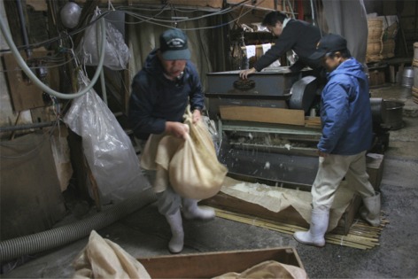 蒸した米を小分けにして運ぶ様子の写真