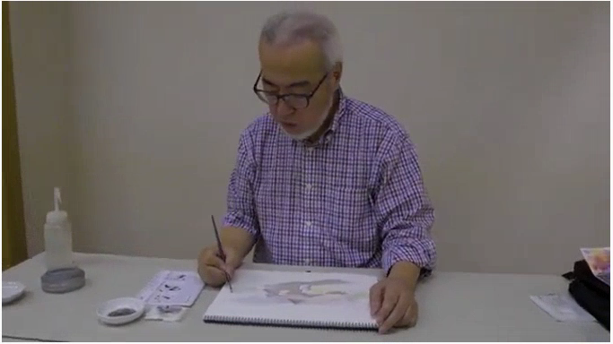 スケッチブックに描かれた絵に色を重ねていく野村重存さんの写真