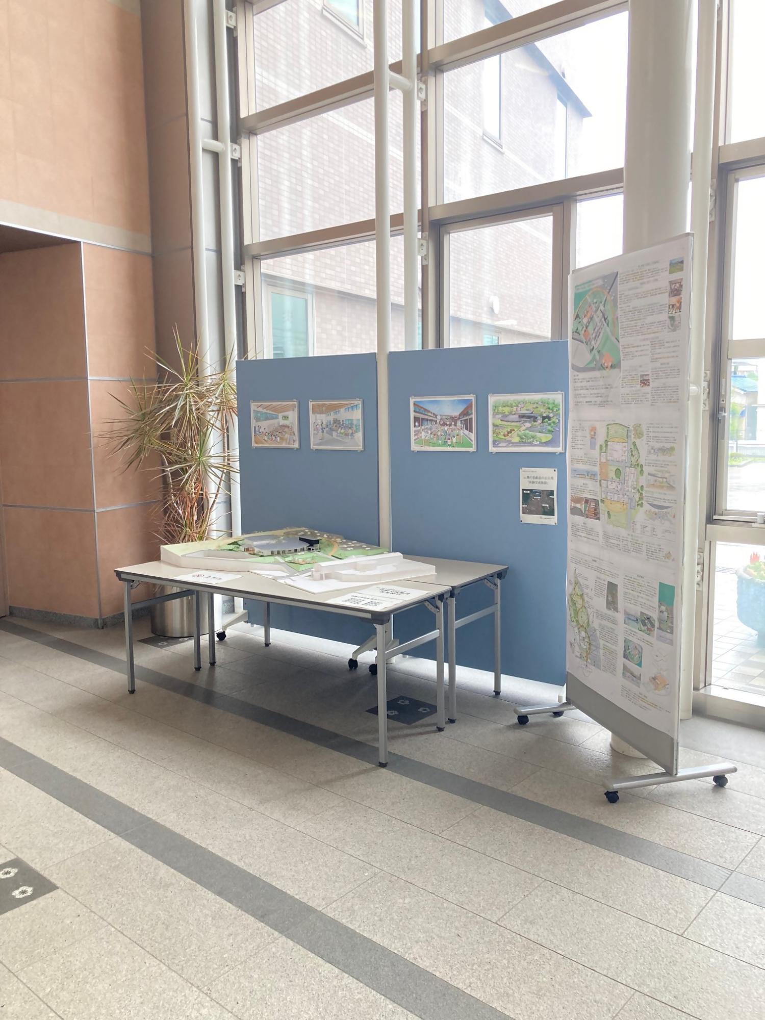 役場のエントランスホールに展示された施設模型と完成予想図（パース）の写真
