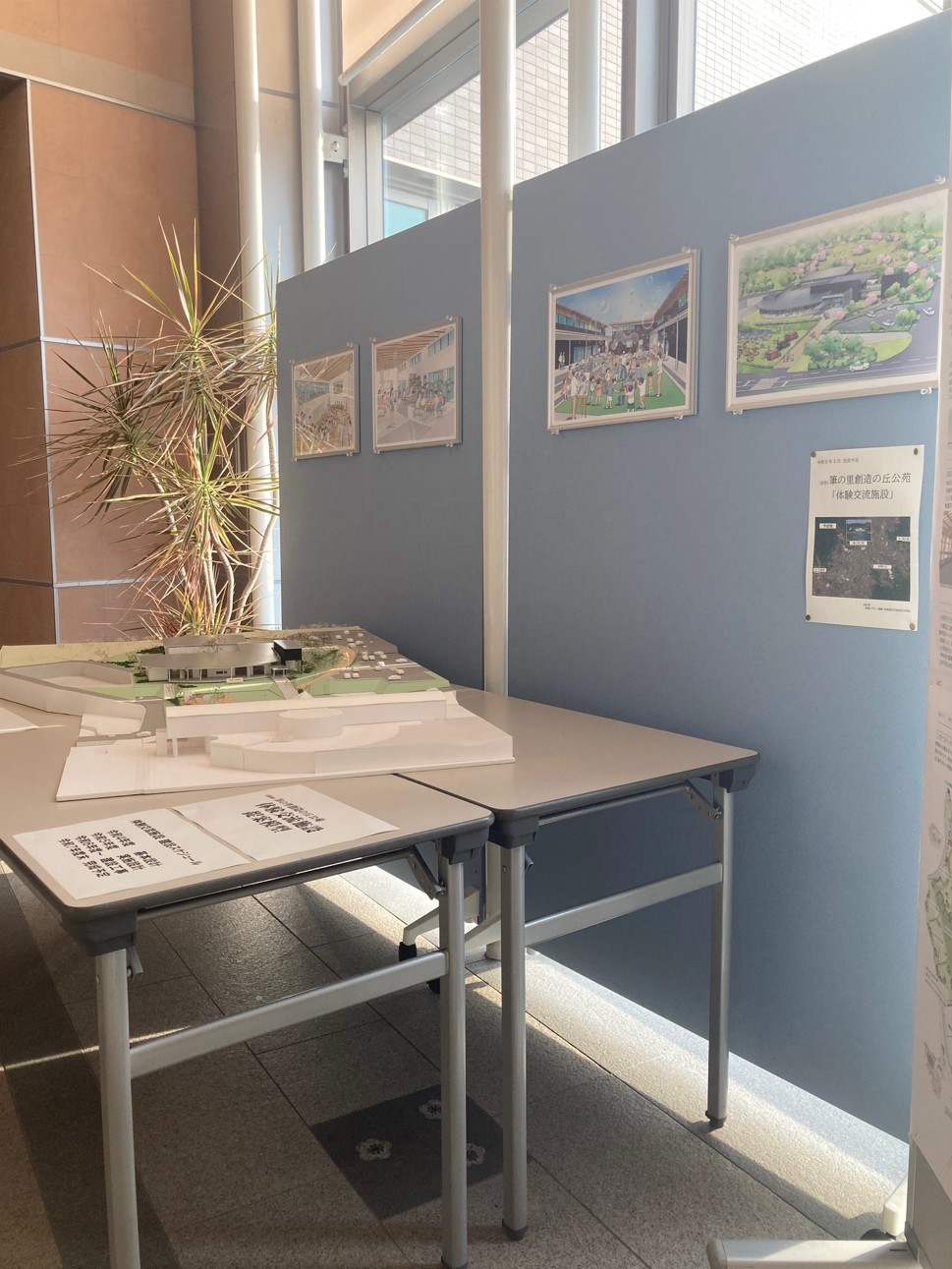 役場のエントランスホールに展示された施設模型と完成予想図（パース）のクローズアップ写真