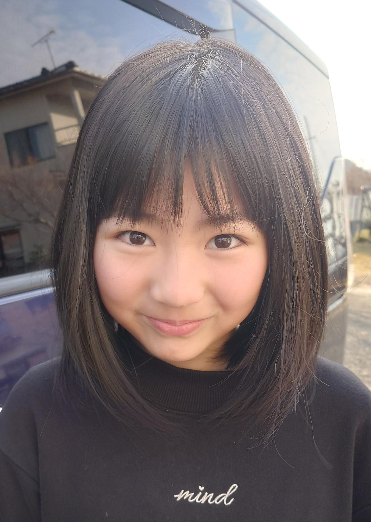 黒いトレーナーを着た笑顔の女の子の写真