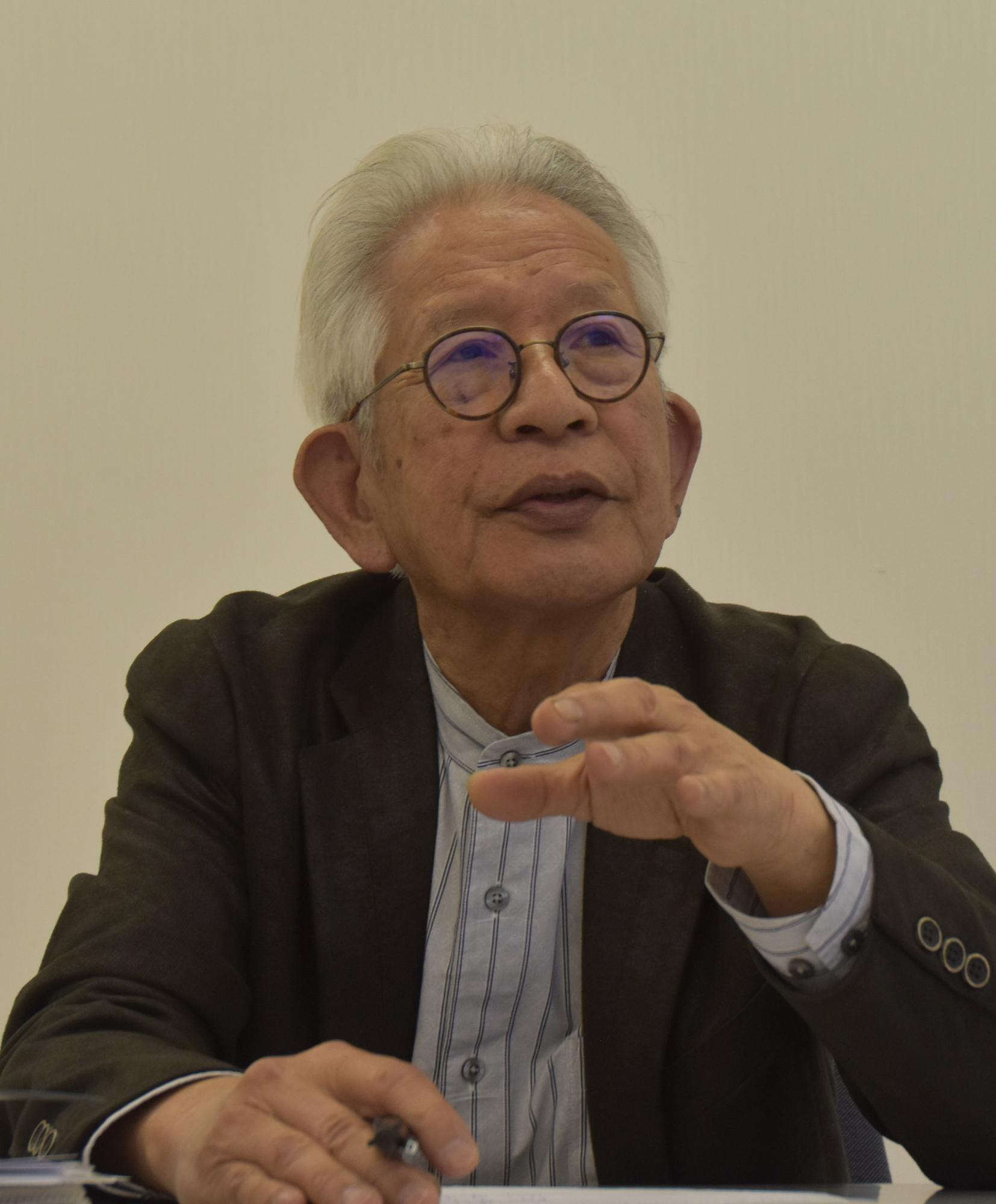 ジャケットを着て質問に答える向久保さんの画像