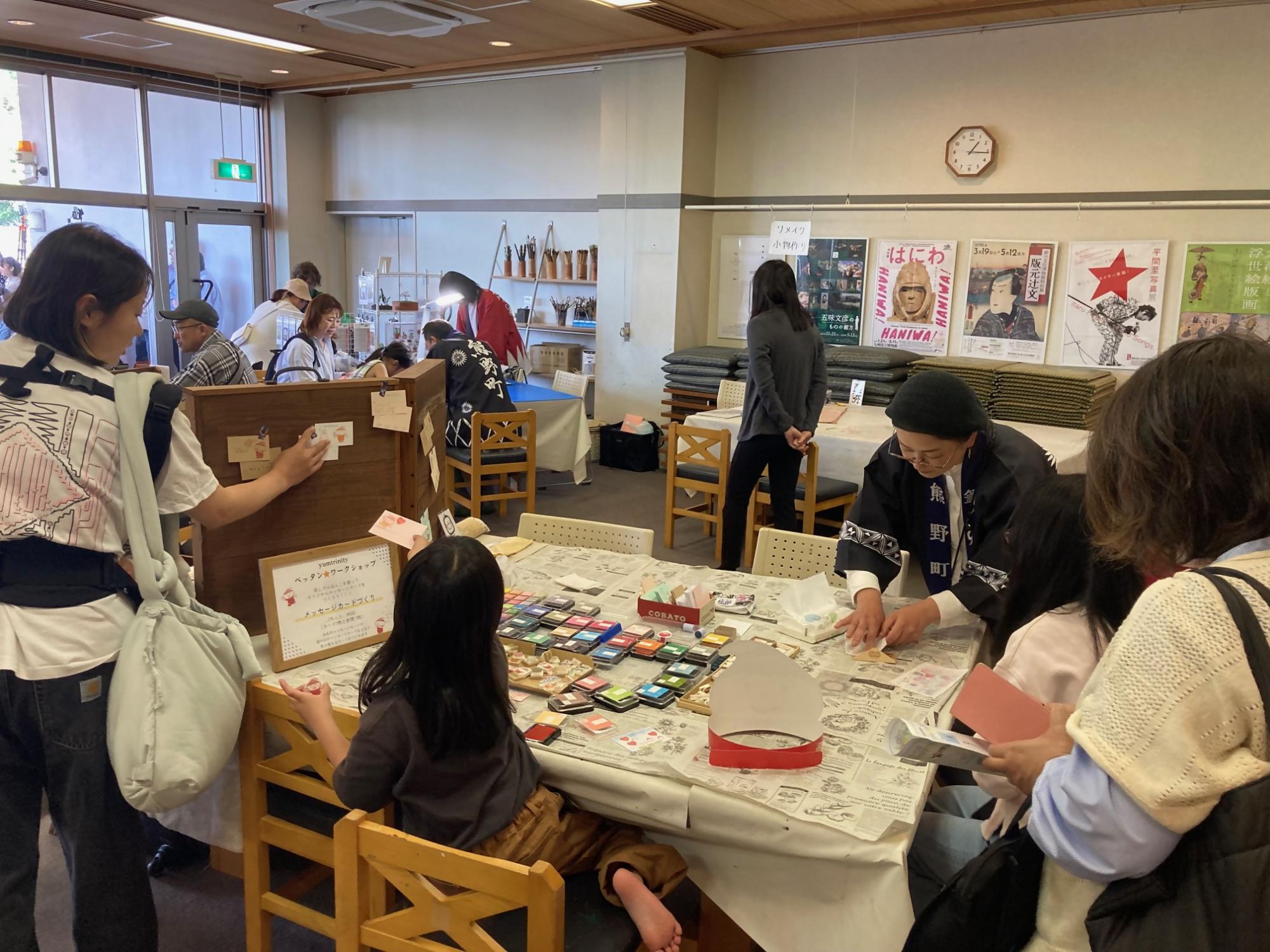 ワークショップブースで消しゴムハンコ作りを体験する子どもたちの写真