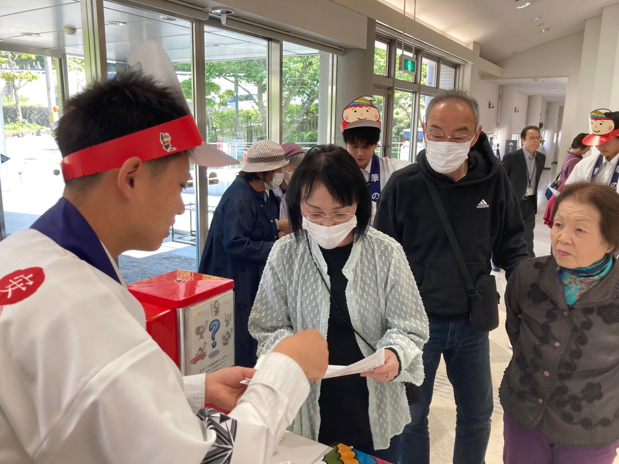 マイ・パレット・ラボのエントランスで係員の説明を受ける来場者の方々の写真