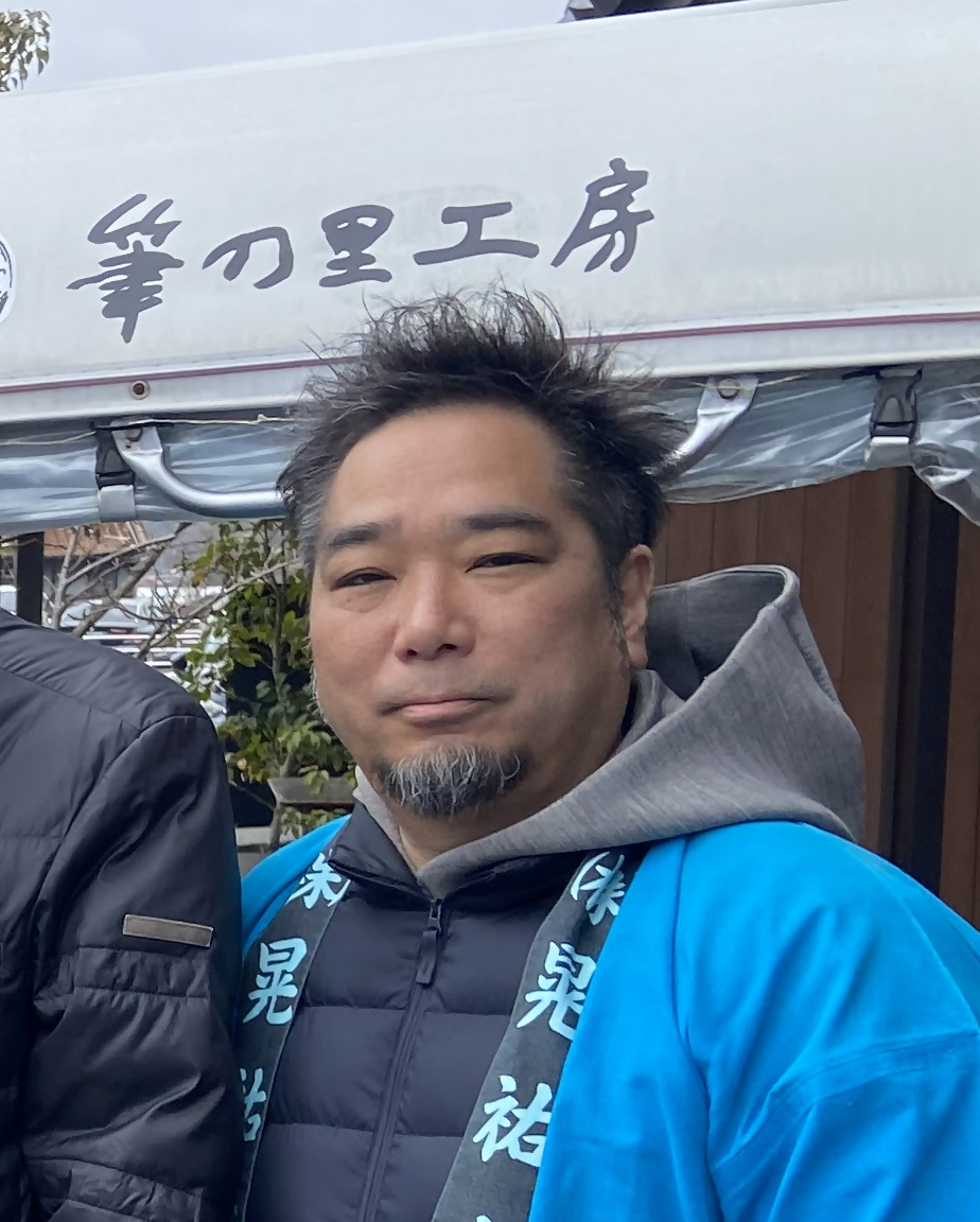 青い法被を着た会長・土屋武美さんの写真