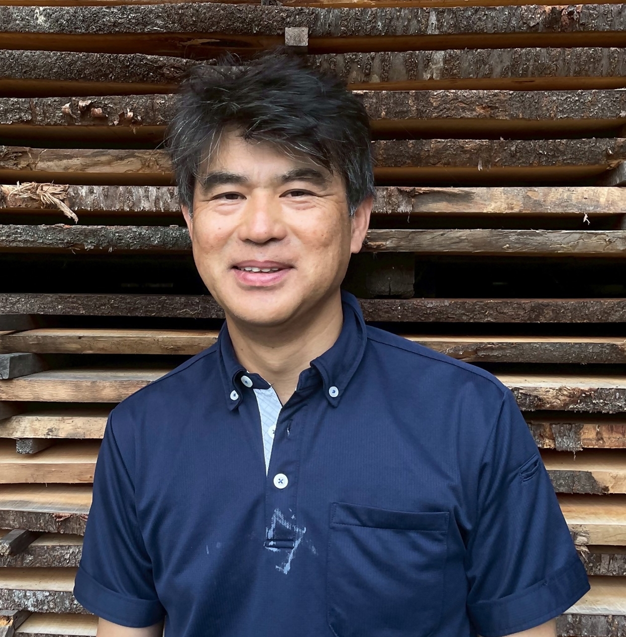青いポロシャツを着た会員・岩永昴士さんの写真