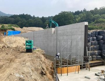 巨大なコンクリートの壁を建設中の工事現場の写真