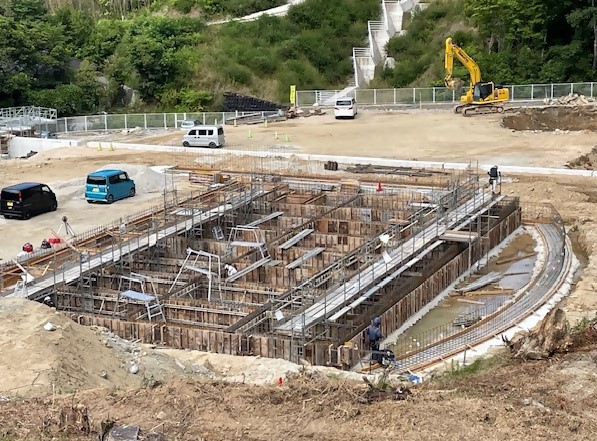 体験ホールの基礎工事で大きな円形にくりぬかれた地面の写真