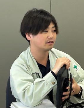 薄緑色の作業服を着ている現場代理人、的場さんの写真