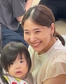 子どもを抱きながら笑顔を見せるお母さんの写真