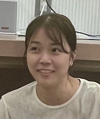 白いTシャツを着て優しい笑顔を見せる女性の写真