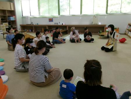 床に座って真剣に支援員の話に耳を傾けている親子たちの写真